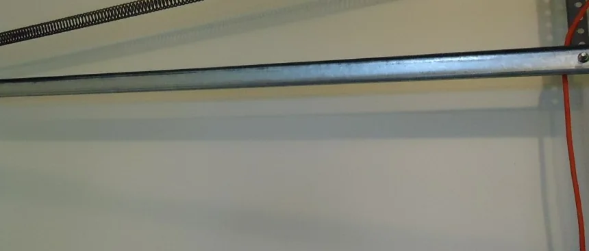 an extension spring and pulley running above a curved garage door track