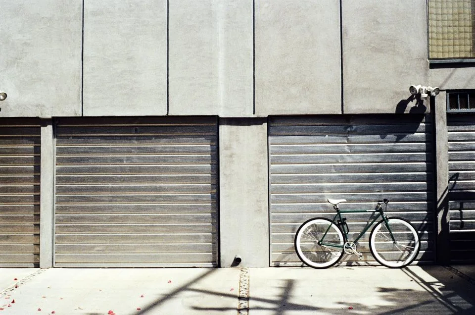 two metal roll-up doors with a bicycle leaning between them